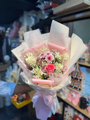 Bouquet of flowers held by a person in a store setting